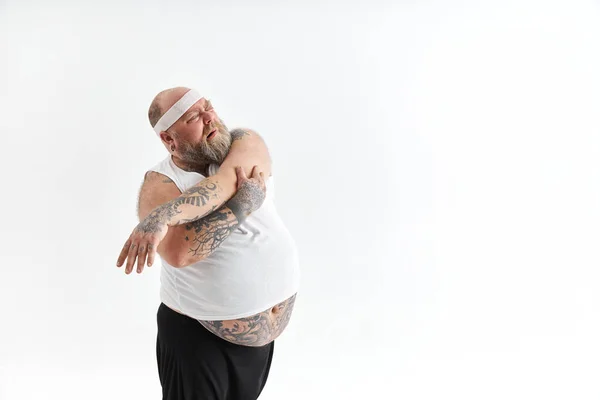 Sportieve dikke man met baard en tatoeages doet aan yoga — Stockfoto