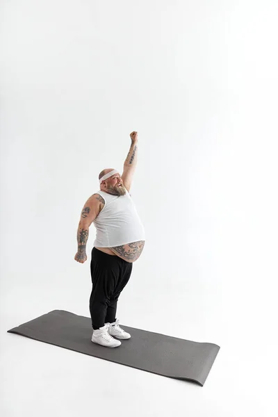 Homme gras sportif avec barbe et tatouages fait du yoga — Photo