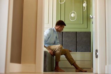 Zeytin duvarının yanında genç ve mutlu bir adam vakit geçiriyor ve gülümsüyor