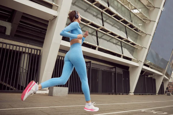 Joven dama en forma está haciendo fitness y jogging en el lugar urbano —  Fotos de Stock