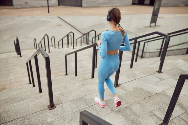 Mulher caucasiana ajuste bonito está fazendo exercícios ao ar livre na cidade — Fotografia de Stock