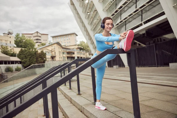 Hermoso ajuste mujer caucásica está haciendo ejercicios al aire libre en la ciudad —  Fotos de Stock