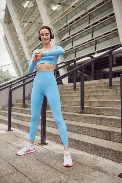 Hermoso ajuste mujer caucásica está haciendo ejercicios al aire libre en la ciudad — Foto de Stock