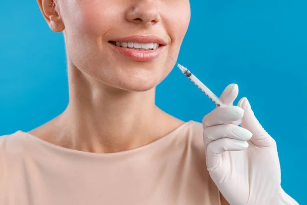 Detailní záběr usměvavé ženy dostávající botoxovou injekci do rtů od kosmetičky — Stock fotografie