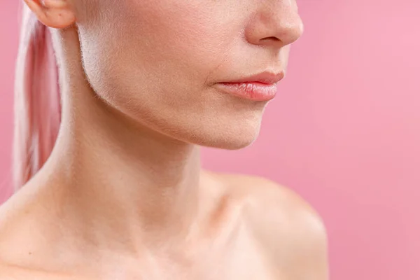Primer plano de perfecta piel fresca de mujer joven con pelo rosa aislado sobre fondo rosa — Foto de Stock