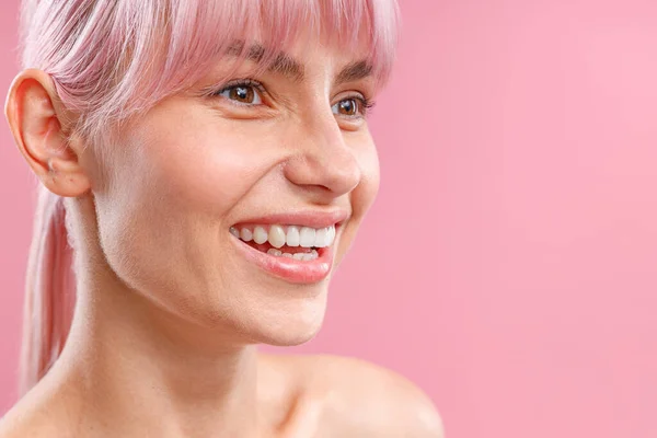 Nahaufnahme Portrait der schönen jungen Frau mit rosa Haaren und frisch glühender Haut weglächeln, posiert isoliert über rosa Hintergrund — Stockfoto