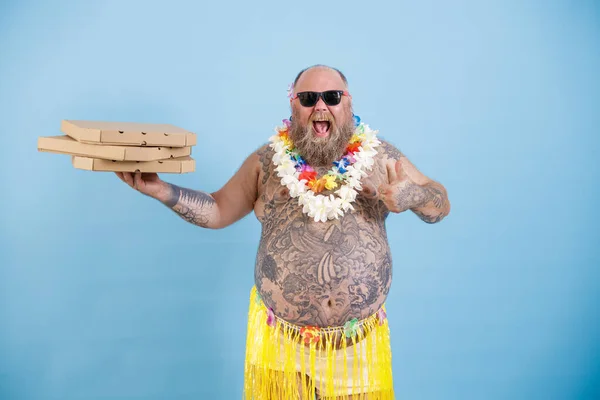 꽃밭을 가진 행복 한 뚱뚱 한 남자가 밝은 푸른 배경에 피자 상자를 들고 있다 — 스톡 사진