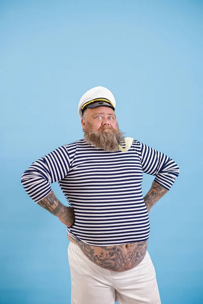 Selbstbewusster Mann mit Übergewicht im Matrosenanzug hält die Hände an der Taille auf hellblauem Hintergrund — Stockfoto