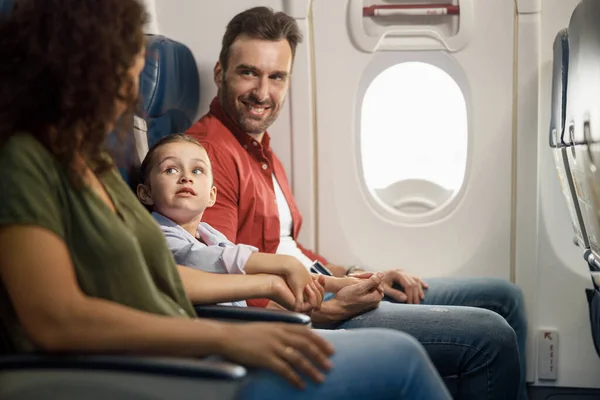 Glada kaukasiska familj föräldrar med liten dotter håller hand tillsammans medan du sitter på flygplanet — Stockfoto