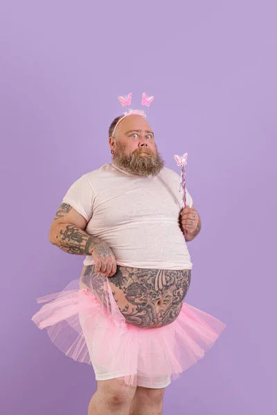 Expressieve man van middelbare leeftijd met overgewicht dragen fee pak poses op paarse achtergrond — Stockfoto