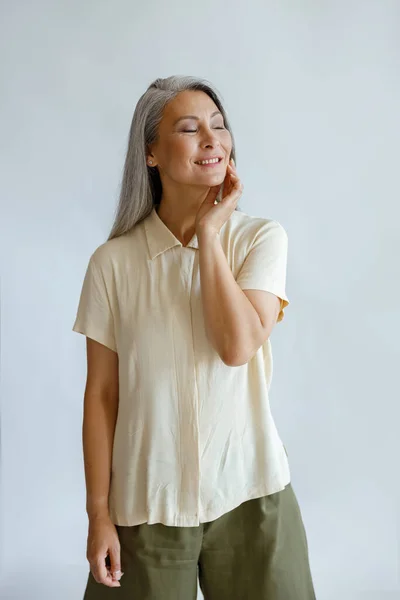 Alegre dama intermedia en ropa casual con estilo se levanta sobre fondo gris claro —  Fotos de Stock