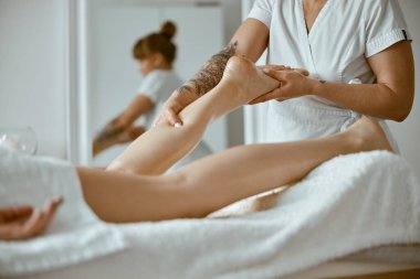 Profesyonel Kafkas uzmanı modern minimalist salonda bacak mesajı veriyor.