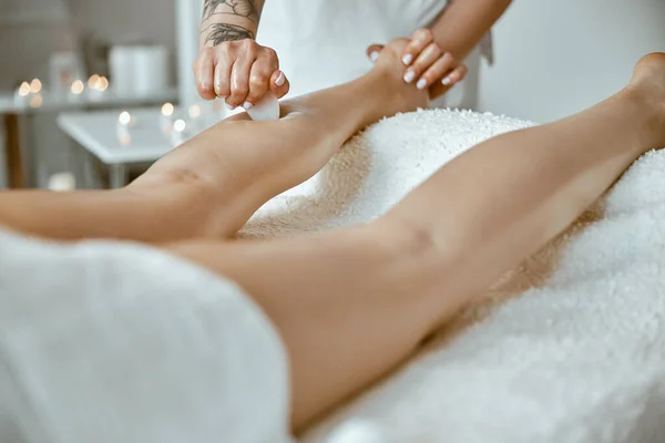 Massagist kvinna gör professionell benmassage i modern salong — Stockfoto