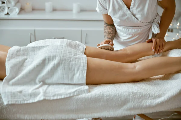 Självsäker kvinnlig specialist gör anticellulite ben massage till vackra friska kaukasiska kvinnliga klienten — Stockfoto