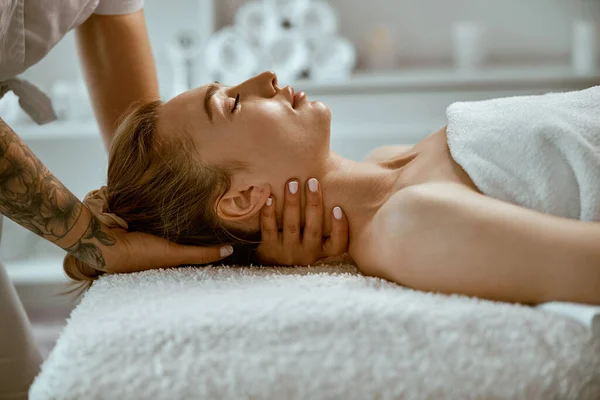 Vuxen kvinnlig specialist gör hals massage till en ung naturlig skönhet kvinnlig klient — Stockfoto