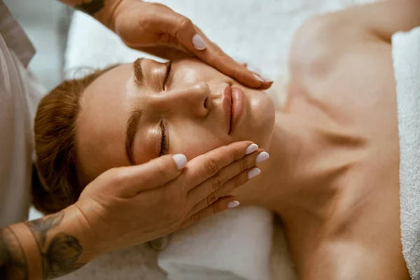 Thérapeute fait visage massage relaxant à une jeune femme dans l'armoire de bien-être moderne — Photo