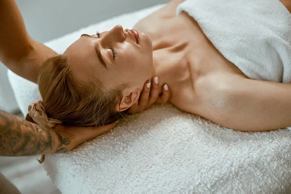 Adult female specialist is doing neck massage to a young natural beautyful female client — Stock Photo, Image