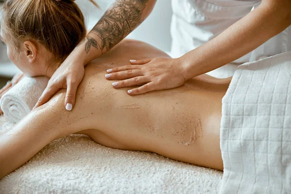 Spécialiste féminin confiant fait massage du corps relaxant pour dame caucasienne mince beautyful au salon de spa minimaliste — Photo