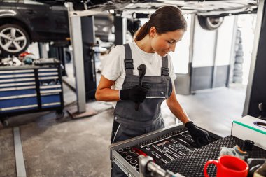 Kendini adamış bir tamirci özenle bir garajda aletleri organize ediyor, uzmanlığını sergiliyor ve sanatına odaklanıyor.