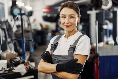 Yetenekli bir kadın tamirci, enerjik ve yoğun bir garaj ortamında geniş uzmanlığını gururla sergiliyor.