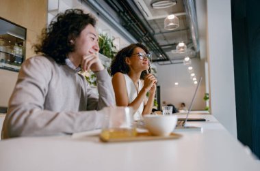 Bilgisayarla derin düşüncelere dalmış, samimi ve sıcak renkleri ve şehirleri olan sıradan ama profesyonel bir ortam.