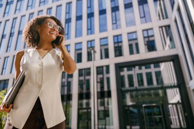 Hırslı iş kadını gözlüğünü hareketli şehir manzarasına ayarlarken kendine güveni tam.