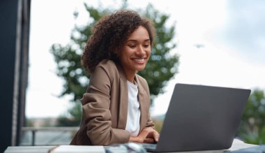 Laptop 'ta siyah geliştirici kodlama, yakınlarda kahve, odaklanmış ifade, kod satırları yazarken,