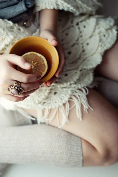 Filiżankę herbaty w dłoni dziewczyny. nieostrość — Zdjęcie stockowe
