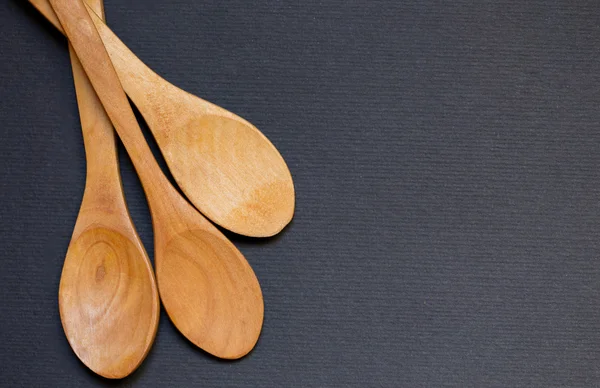 Three wooded spoons on a dark baclground — Stock Photo, Image