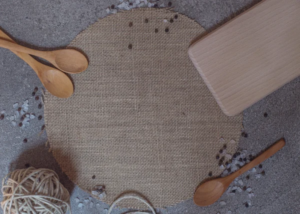 Cucharas de madera, tabla de cortar y guisar sobre el fondo de piedra — Foto de Stock