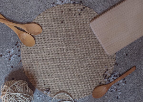 Wooden spoons, cutting board and clew on the stone background