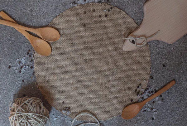 Cucharas de madera, tabla de cortar y guisar sobre el fondo de piedra — Foto de Stock