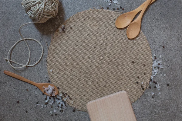 Cucharas de madera, tabla de cortar y guisar sobre el fondo de piedra — Foto de Stock