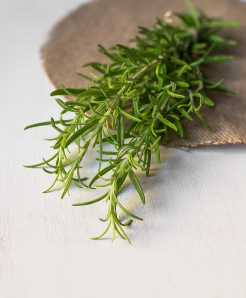 Bunch of rosemary on white wooden background — Stock Photo, Image