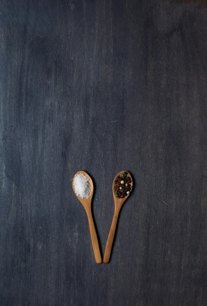 Two wooden spoons with salt and pepper — Stock Photo, Image