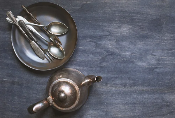 Antique cutlery with old teapot on wooden background — Stock Photo, Image