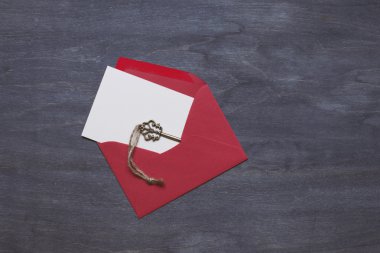 Anahtar koyu ahşap zemin üzerine kırmızı zarf