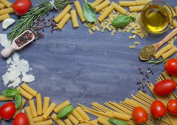 Makarna, çeşni ve ahşap arka plan üzerinde domates