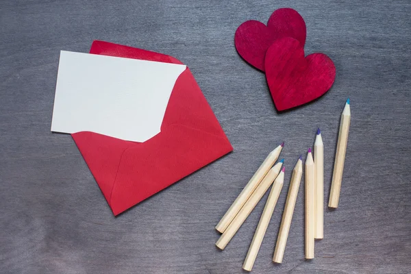 Davetiyeli kırmızı zarf ve ahşap kırmızı Kalpler