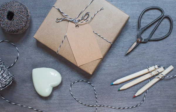 Caja de regalo con corazón de cerámica, lápices y tijeras viejas — Foto de Stock