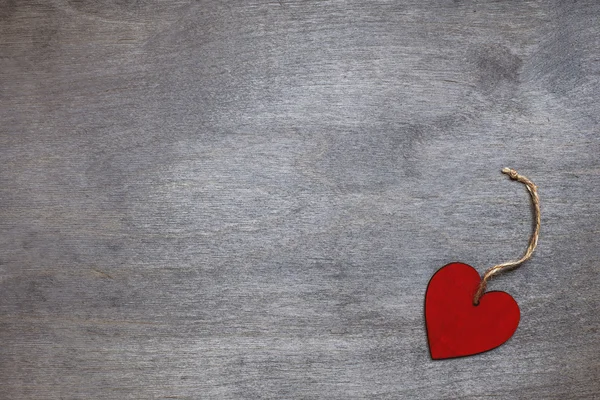 Coeur en bois rouge sur fond en bois — Photo