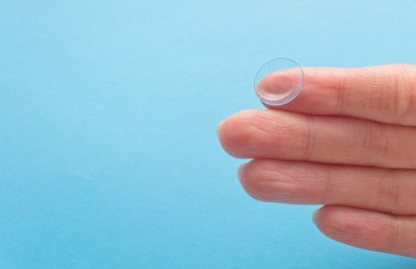 Mavi arka planda insan elinin kontakt lensi. Seçici odaklanma. Kapat.