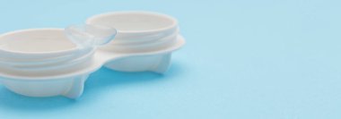 Yumuşak kontak lensler ve mavi arka planda beyaz plastik kutu. Kapatın. Seçici odaklanma. Pankart