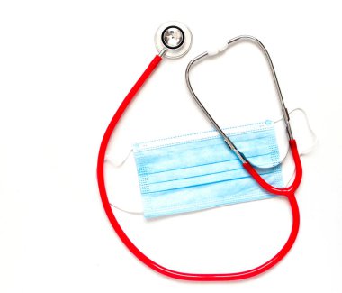 Tıbbi kırmızı steteskop ve beyaz arka planda mavi maske. Boşluğu kopyala.