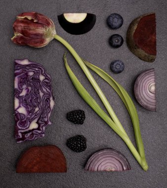 Lale, yumurta, yabanmersini, pancar kökü, siyah masada kırmızı soğan deseni. Geometrik düz mor bitkiler konsepti