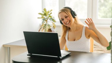 Avrupalı genç iş kadını öğrenci öğretmenleri internetteki bilgisayar konuşmalarında kablosuz video konferansı takıyor. İnternet sohbetlerinde öğretmeyi öğrenin, internetten uzaktan ağ öğrenme kavramı