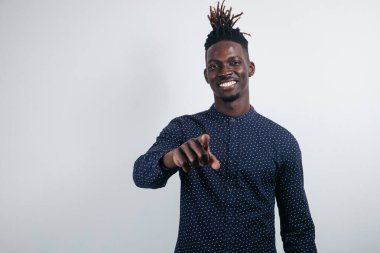 Sıradan bir tişört giyen, gülümseyen bir melez adamın yatay stüdyo fotoğrafı. Yüzünde pozitif bir ifade olan bir şeyin reklamı. Mesajını kopyalamak için boş bir alan.