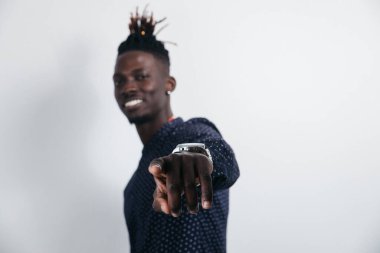 Sıradan bir tişört giyen, gülümseyen bir melez adamın yatay stüdyo fotoğrafı. Yüzünde pozitif bir ifade olan bir şeyin reklamı. Mesajını kopyalamak için boş bir alan.