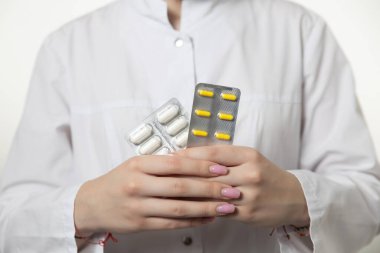 Kadın doktor, iş yerinde farklı tablet şişliklerinden oluşan el çantası tutuyor. Panacea, hayat kurtarma servisi, ilaç reçetesi, yasal eczane, hastalık tedavisi, tansiyon konsepti. Posta kutusu görünümü