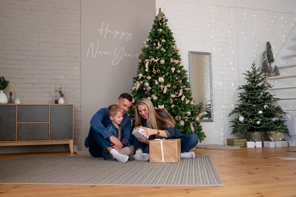Merry Christmas and happy holidays mom, dad and son sort out gifts. A loving family enjoys the New Year\'s mood